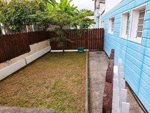 a backyard with a fence and a tree at Charme du Nord 1 in Sainte-Clotilde
