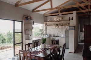 a kitchen with a table and chairs and a kitchen with a window at Riverbed Africa in Lydenburg