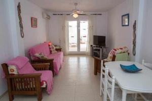 - un salon doté d'un mobilier rose et d'une table dans l'établissement Apartamento en zona tranquila y cercano a playas, à Mojácar