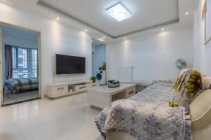a bedroom with a bed and a flat screen tv at Family stay Apartement Livable East City in Huainan
