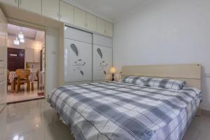 a bedroom with a bed with a blue and white comforter at Family stay Apartement Livable East City in Huainan