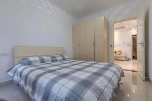 Un dormitorio con una cama con una manta de cuadros azul y blanco en Family stay Apartement Livable East City, en Huainan