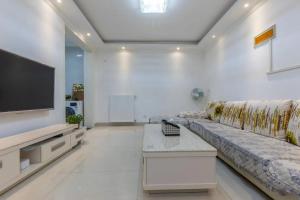 sala de estar con sofá y TV de pantalla plana en Family stay Apartement Livable East City en Huainan