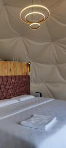 a bed in a tent with a white towel on it at Divercity Luxury Glamp in Kodaikānāl