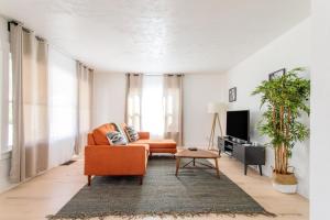 a living room with an orange couch and a tv at Sumner 2br w parking nr parks schools markets SEA-684 in Puyallup