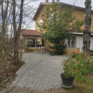a house with a gravel driveway in front of it at La Frênaie in Saint-Cyr-sur-le-Rhône