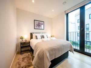 a bedroom with a large bed and a large window at Pass the Keys Blend of Luxury and Elegance in the Heart of London in London