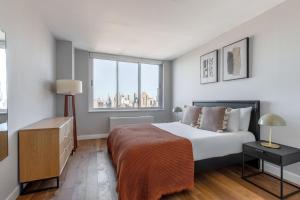 um quarto com uma cama e uma grande janela em Midtown West 2br w gym roofdeck nr Hudson NYC-1395 em Nova York