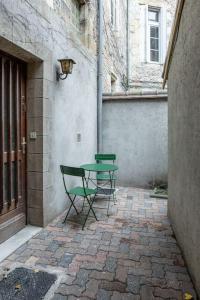 2 sillas y una mesa en un patio de ladrillo en Duplex avec patio - Quartier historique, en Moulins