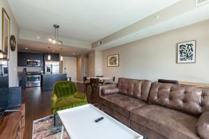 a living room with a brown couch and a kitchen at Reston 1br w pool wd close to shopping mall WDC-828 in Reston