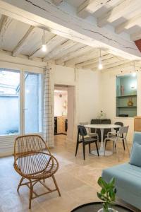 Una sala de estar con un sofá y una mesa con sillas. en Duplex avec patio - Quartier historique, en Moulins