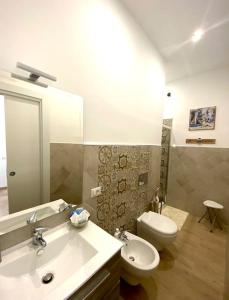 y baño con lavabo, aseo y espejo. en Cuore d’Orlando apartment, en Capo dʼOrlando