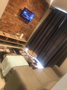 a room with a couch and a table and a television at Euphoria in Nelspruit