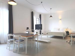 een woonkamer met een tafel en stoelen en een bed bij appartamenti olivo in Vigevano
