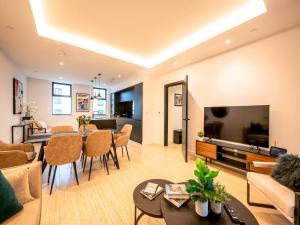 uma sala de estar com uma mesa e uma sala de jantar em Pass the Keys Modern Exuberance and Luxury at Lucent House em Londres