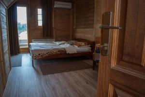 Schlafzimmer mit einem Bett, einem Fenster und einer Tür in der Unterkunft Hostel Fortuna in Banja Luka