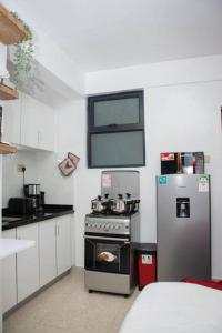 a kitchen with a stove and a refrigerator at GWETH STUDIO APARTMENT in Nairobi