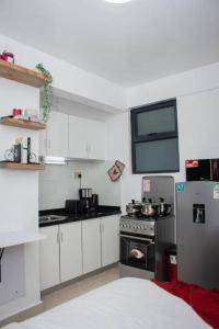 a kitchen with white cabinets and a stainless steel refrigerator at GWETH STUDIO APARTMENT in Nairobi