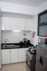 a kitchen with white cabinets and a stainless steel stove at GWETH STUDIO APARTMENT in Nairobi