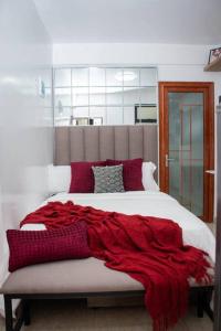 een slaapkamer met een rode deken op een bed bij GWETH STUDIO APARTMENT in Nairobi
