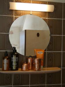 uma prateleira de casa de banho com um espelho e produtos sobre ele em De Staakenborgh em Bourtange