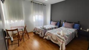 a bedroom with two beds and a table and chairs at Hello Villarreal Pension in Villareal