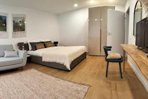 ein Schlafzimmer mit einem Bett, einem Stuhl und einem Fernseher in der Unterkunft Altstadt House in Braşov