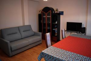 un soggiorno con divano, sedia e TV di Mirador Alegre a El Burgo de Osma