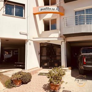a building with a car parked in front of it at 2-Bedroom Apartment Pamfilya 7 by MyGuest Cyprus in Famagusta