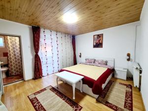 sypialnia z łóżkiem i stołem w obiekcie Vila Giulia Voineasa w mieście Voineasa
