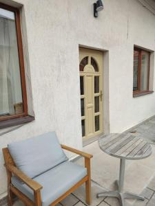 eine Terrasse mit einem Tisch, einem Stuhl, einem Tisch und einem Fenster in der Unterkunft Altstadt House in Braşov