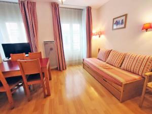 sala de estar con sofá y mesa de comedor en Val de Jade, Oo, T2, centre Luchon, wifi, casier à skis, 4 personnes, en Luchon