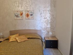 a bedroom with a bed and three paintings on the wall at Love & Laughter in Porto SantʼElpidio