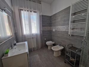 La salle de bains est pourvue de toilettes, d'un lavabo et de toilettes. dans l'établissement Love & Laughter, à Porto SantʼElpidio