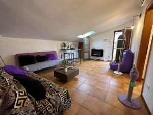 un salon avec un canapé violet et une chambre avec dans l'établissement Tra il Mare e il centro di Viareggio - Casa Lilla, à Viareggio