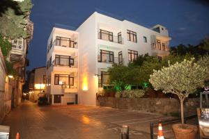 a white apartment building at night with a street at Remarkable Flat with Balcony near Hadrian's Gate in Antalya