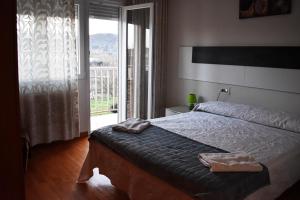- une chambre avec un lit et une grande fenêtre dans l'établissement Mirador Alegre, à El Burgo de Osma
