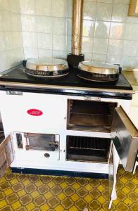 a stove with two pans on top of it at House At the Heart of Shellharbour in Shellharbour