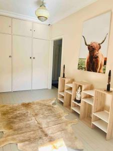 a living room with a painting of a bull on the wall at House At the Heart of Shellharbour in Shellharbour