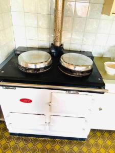 two pans sitting on top of a stove in a kitchen at House At the Heart of Shellharbour in Shellharbour