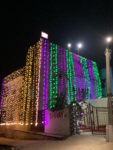 a building with christmas lights on the side of it at SHIVAY Guest House in Deoghar