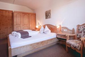 a bedroom with a bed and a chair and a table at Apartments Pitztaler Nachtigall in Arzl im Pitztal