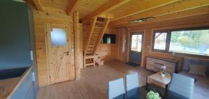 a living room with a staircase in a log cabin at Domki z bala przy plaży Orle Jezioro Głuszyńskie in Orle