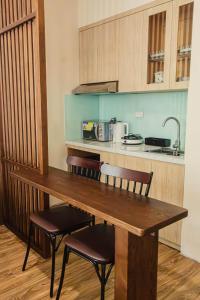 a kitchen with a wooden table and two chairs at Areca Boutique Apartments Hanoi in Hanoi