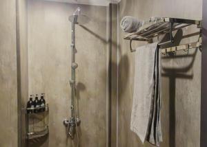 a bathroom with a shower with towels on a shelf at Areca Boutique Apartments Hanoi in Hanoi