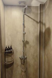 a shower in a bathroom with bottles on a shelf at Areca Boutique Apartments Hanoi in Hanoi