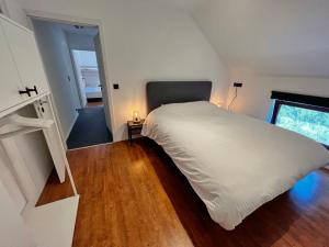 バルヴォーにあるChateau Angelusのベッドルーム1室(大きな白いベッド1台、階段付)