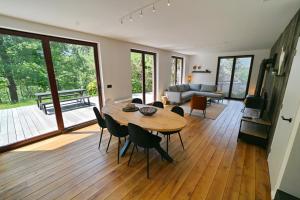 een woonkamer met een houten tafel en stoelen bij Chateau Angelus in Barvaux