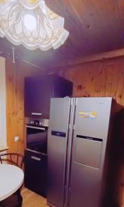 een keuken met een koelkast en een tafel en een licht bij Apartament NG in Wieliszew