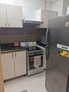 a kitchen with a stove and a refrigerator at Lovely spacious studio with new branded furniture in Dubai